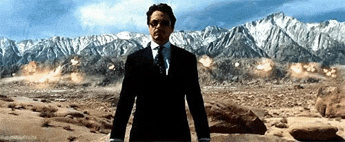 a gif image of robert downey jr. who played the role of tony stark in iron man part one demonstrating jericho missiles which blasts the whole mountain to the us army at the beginning of the movie.
